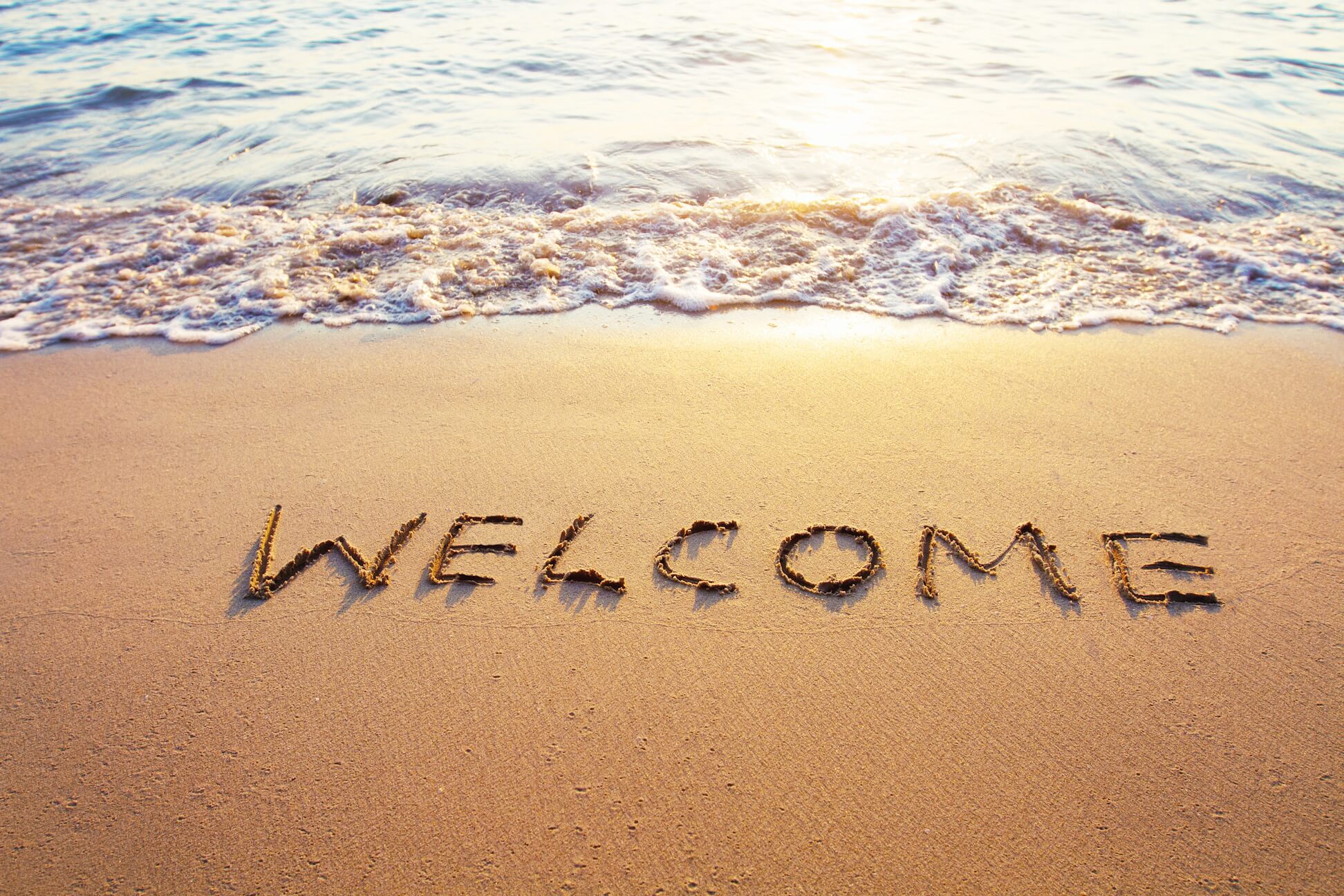 Welcome written in the sand at the beach
